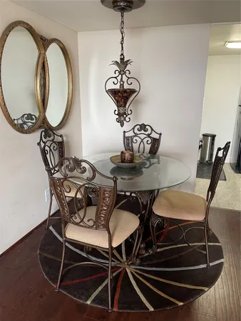 a dining room table with a chandelier and a mirror