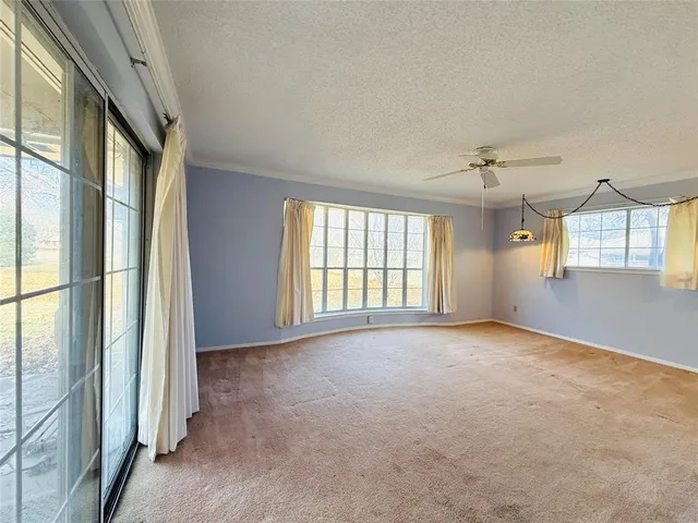 an empty room with windows and chandelier