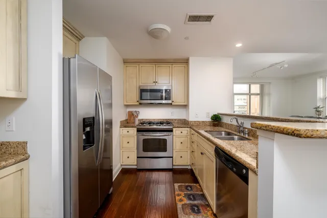 a bedroom with a bed a dresser and a chandelier