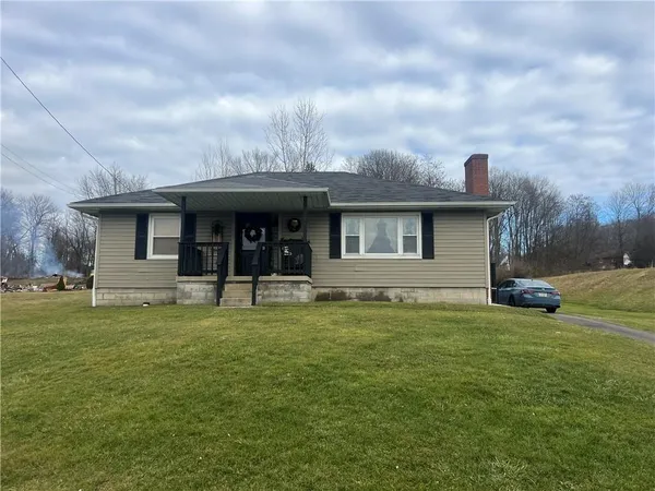 a view of a house with a yard and sitting area