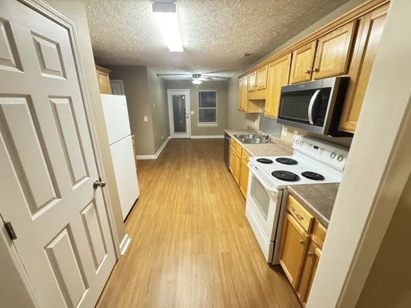 a view of a kitchen with wooden floor and electric appliances