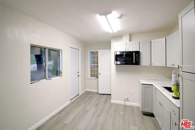 a kitchen with granite countertop a stove and a wooden floors