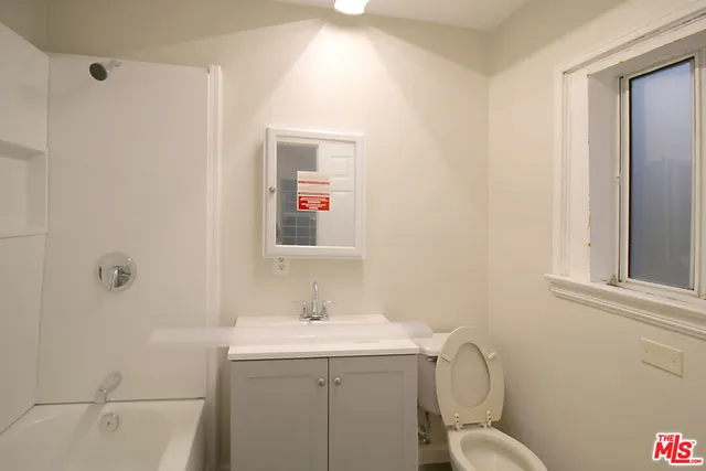 a bathroom with a sink mirror vanity and toilet