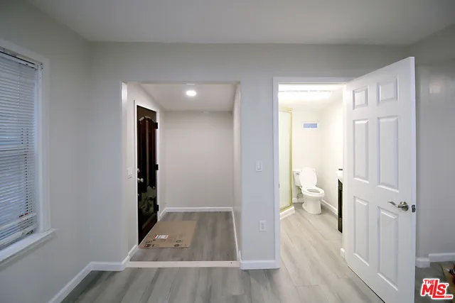 a view of a room with wooden floor and a bathroom