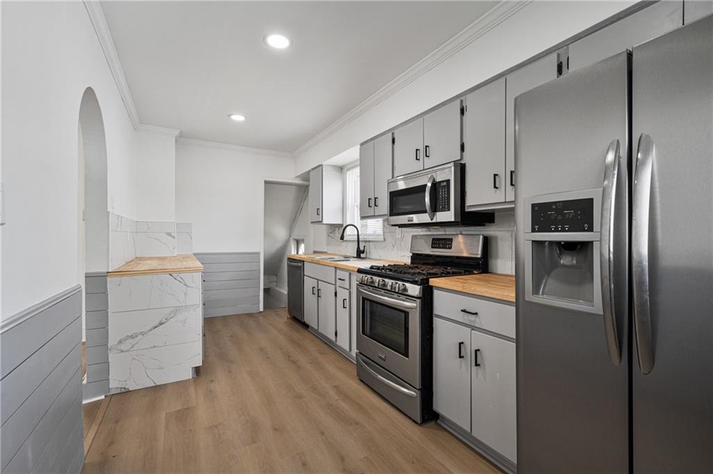 1716 Davidson Street Aliquippa, PA 15001 - Photo 12 of 34 a kitchen with white cabinets and stainless steel appliances