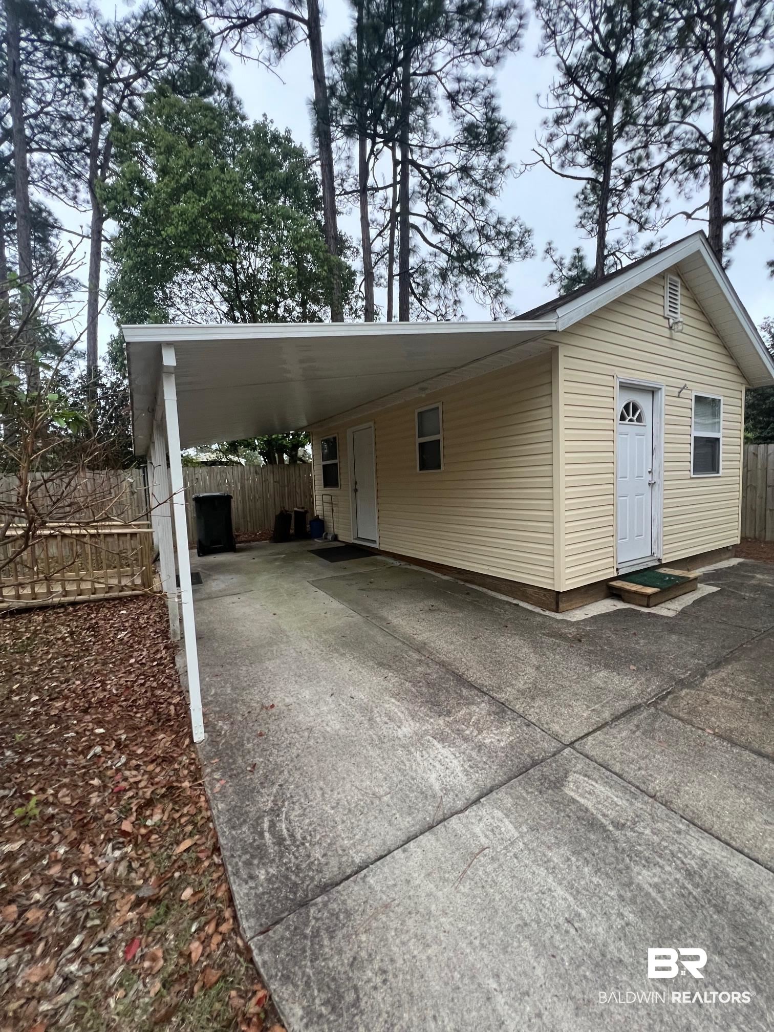 518 Elberta Loop Lillian, AL 36549 - Photo 13 of 38 Exterior space with concrete driveway, a carport, and fence