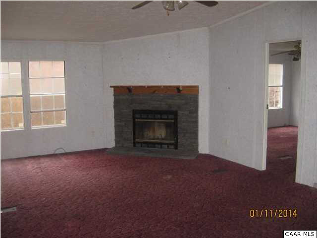 7389 Porters Road Esmont, VA 22937 - Photo 3 of 4 an empty room with a fireplace and window
