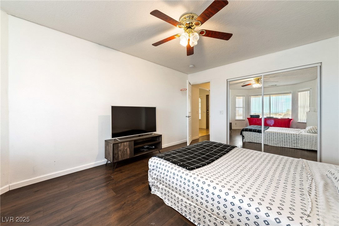 3481 Winery Road Pahrump, NV 89048 - Photo 27 of 34 Bedroom with dark wood-style flooring, baseboards, a ceiling fan, and a closet