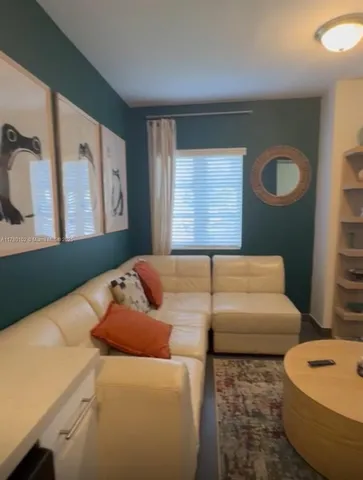 a living room with furniture and wall paintings