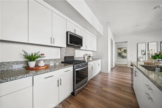 a kitchen with granite countertop white cabinets and white appliances