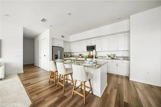 a kitchen with a table chairs a sink dishwasher and cabinets