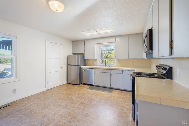 a kitchen with white cabinets and white appliances
