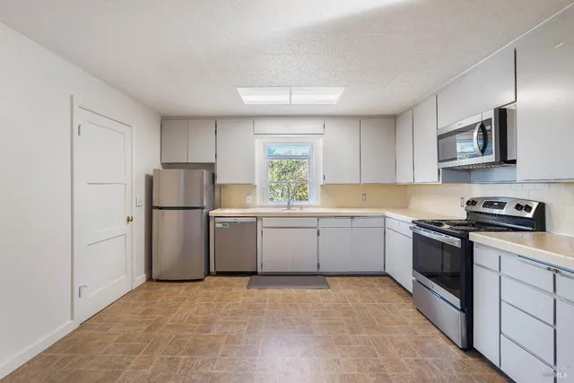a kitchen with cabinets appliances and a sink