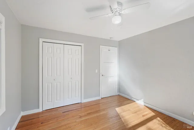 a bathroom with a granite countertop sink a toilet a mirror and a window