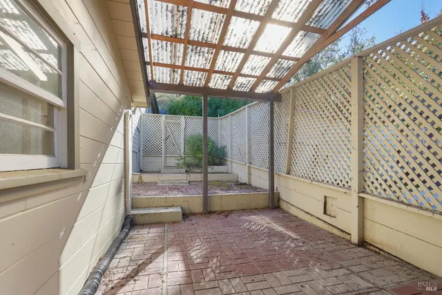 a backyard of a house with barbeque oven and outdoor seating