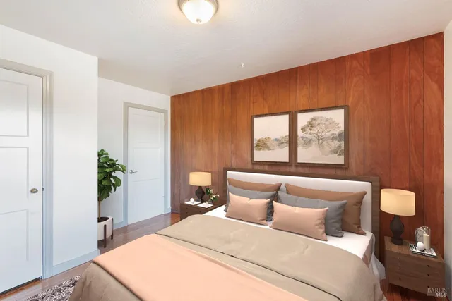 a bedroom with a large bed and a potted plant