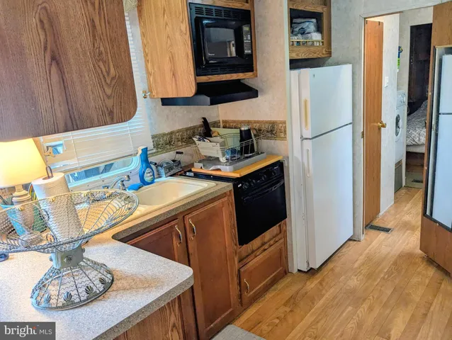 a kitchen with stainless steel appliances granite countertop a sink a stove a refrigerator and a microwave