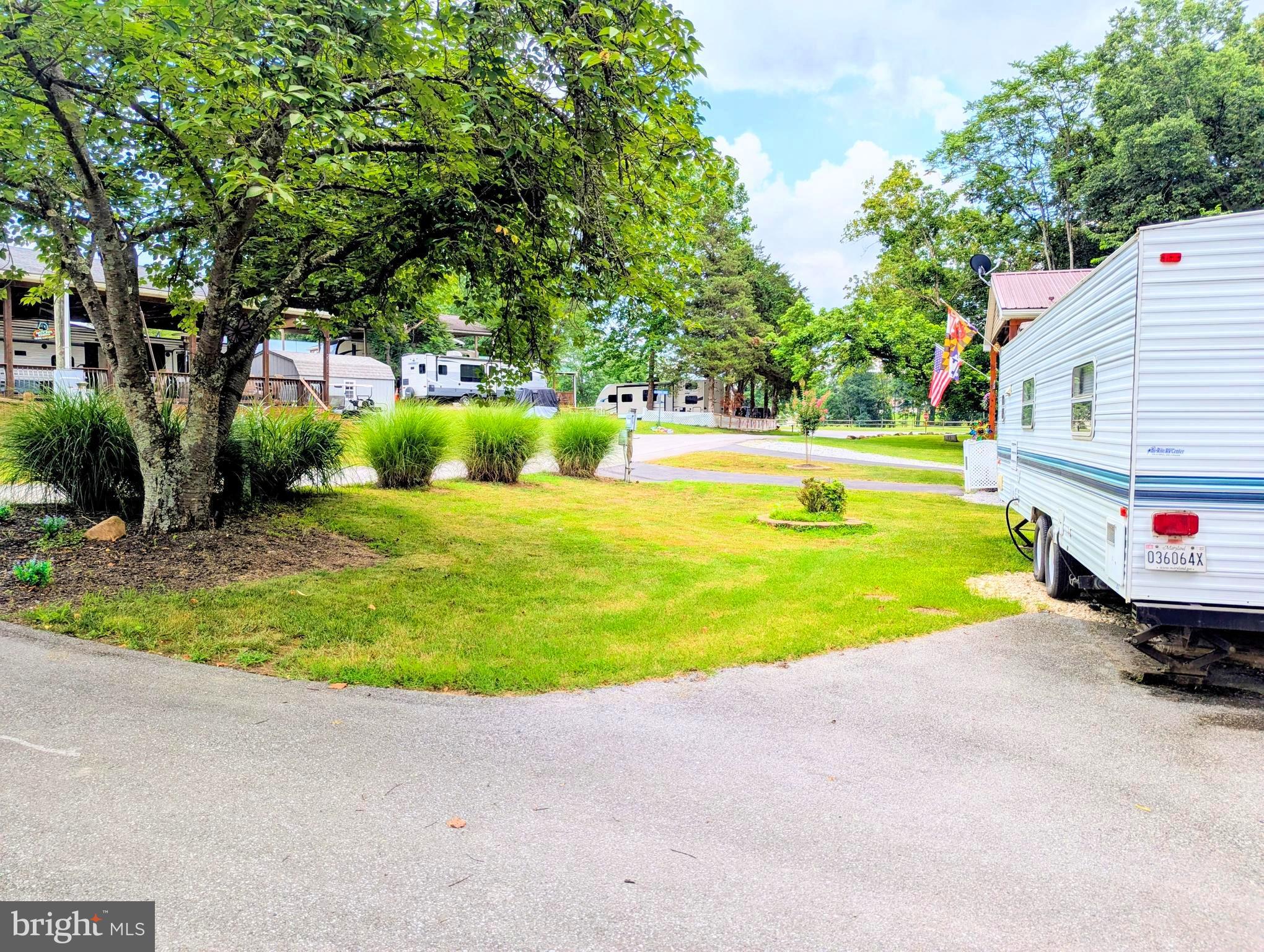 71 & 72 Boo Boo Boulevard Falling Waters, WV 25419 - Photo 4 of 13 a view of a swimming pool with a yard and palm trees