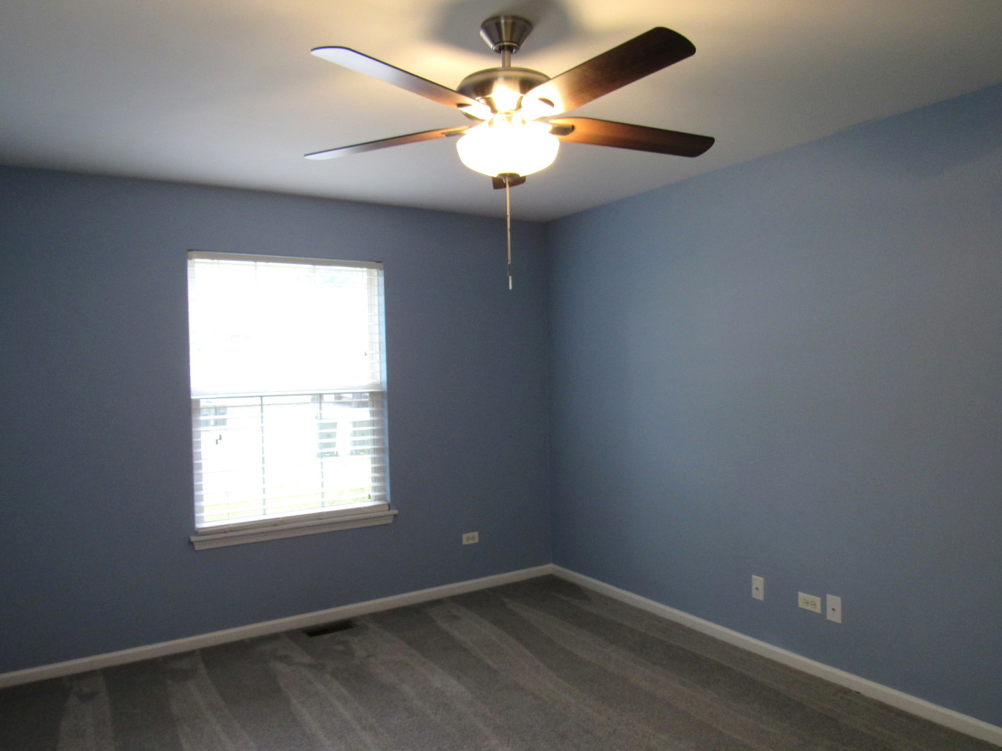 1202 North Red Oak Circle, Unit 2 Round Lake Beach, IL 60073 - Photo 11 of 18 an empty room with a window and a chandelier fan