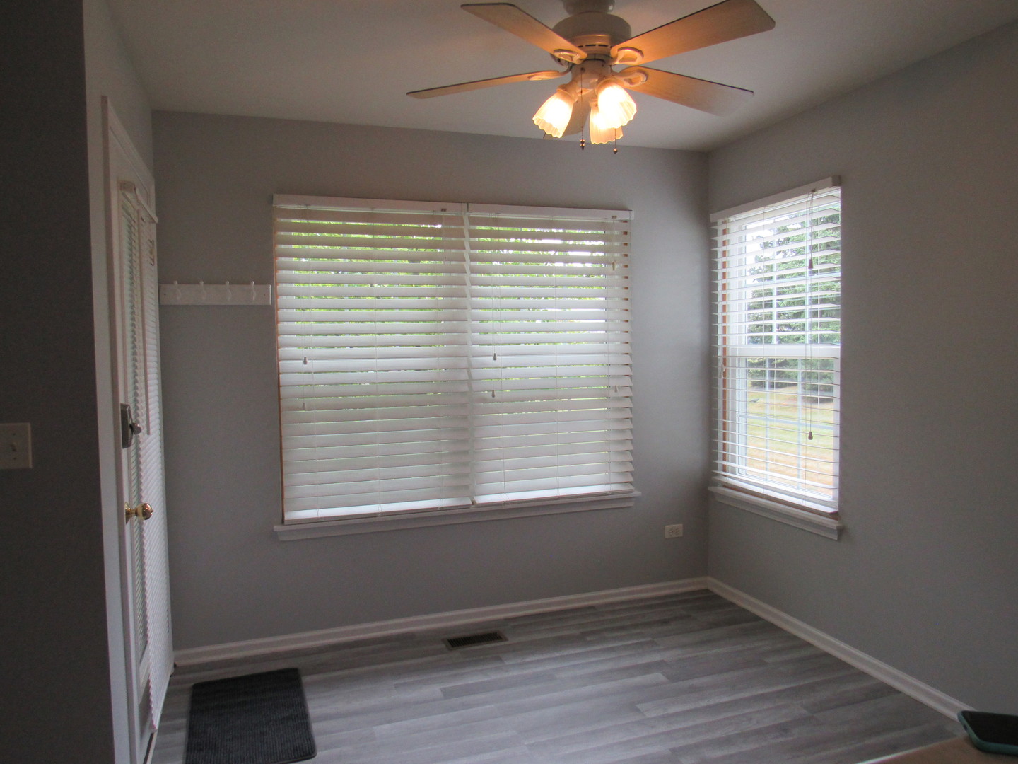 1202 North Red Oak Circle, Unit 2 Round Lake Beach, IL 60073 - Photo 4 of 18 a view of an empty room with wooden floor and a window