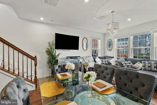 a living room with furniture kitchen view and a flat screen tv
