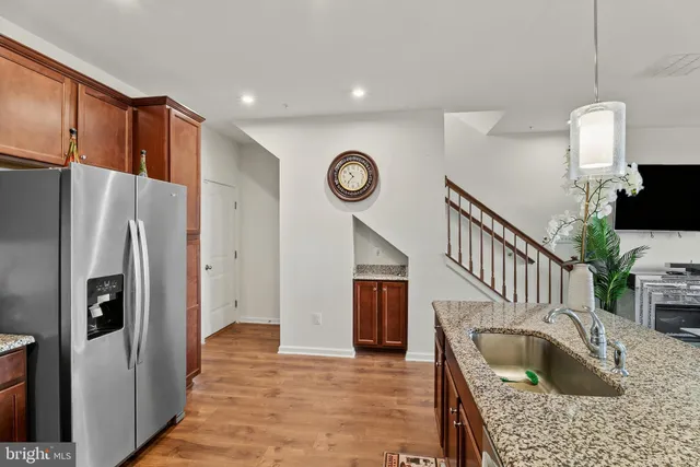 a kitchen with stainless steel appliances granite countertop a refrigerator a oven and a sink