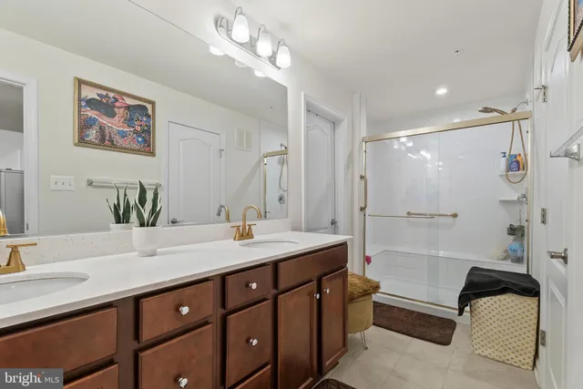 a bathroom with a tub a sink double vanity and shower