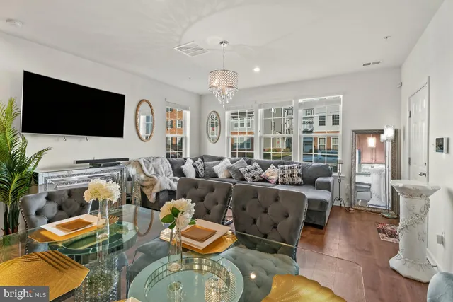 a living room with furniture flat screen tv and wooden floor