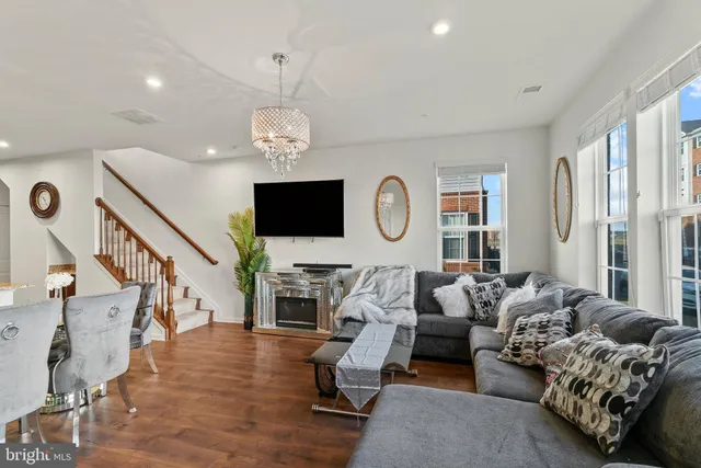 a living room with furniture chandelier and a flat screen tv