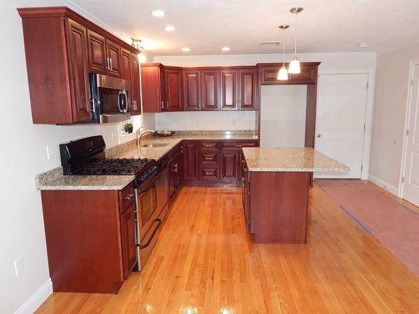 80 Locust Street Brockton, MA 02301 - Photo 7 of 20 a kitchen with stainless steel appliances granite countertop a stove a sink and a refrigerator