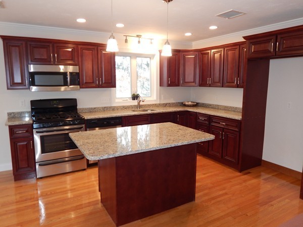 80 Locust Street Brockton, MA 02301 - Photo 9 of 20 a kitchen with kitchen island granite countertop a stove a sink and a refrigerator