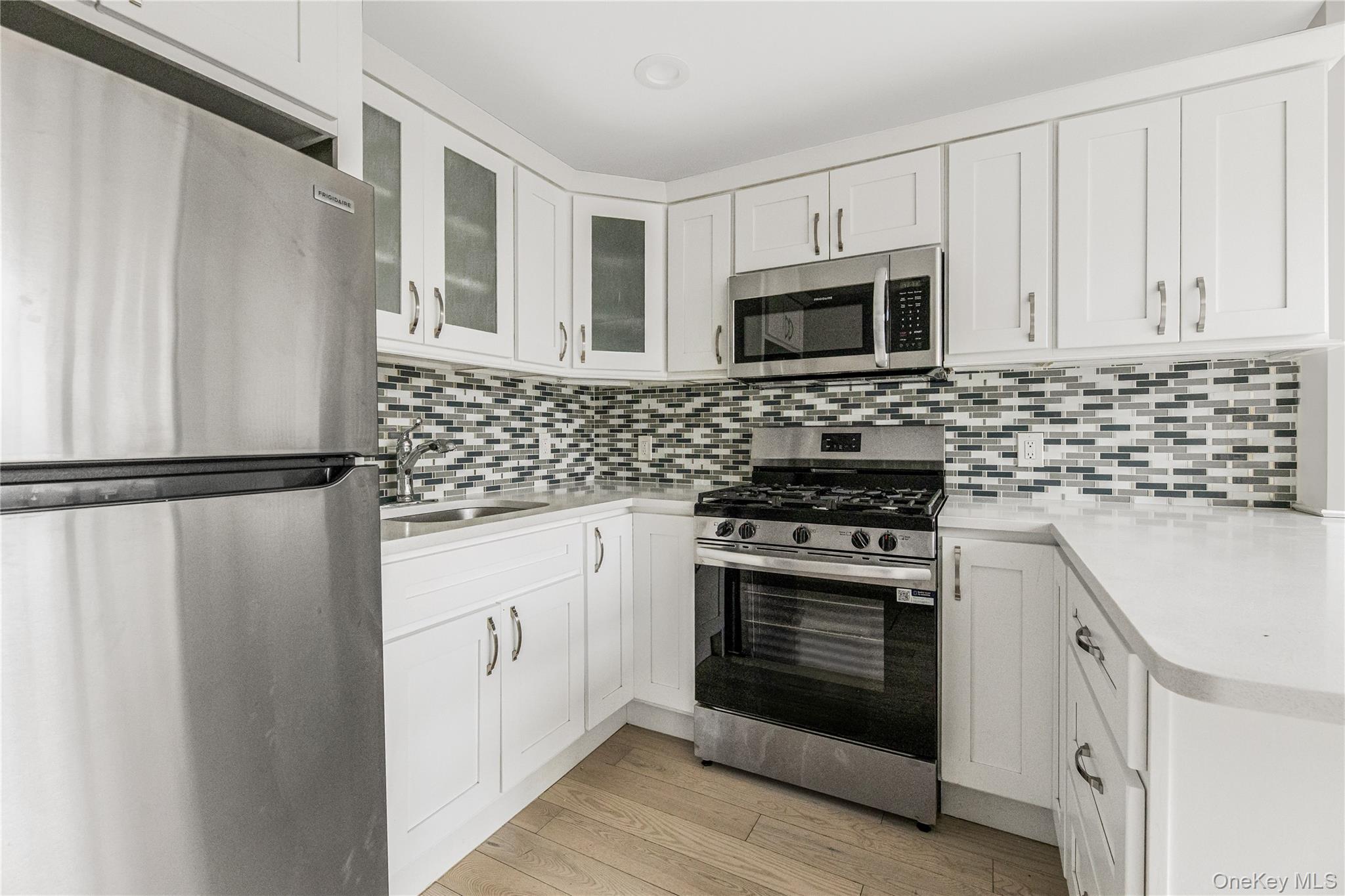 3067 Williamsbridge Road Bronx, NY 10467 - Photo 16 of 29 a kitchen with white cabinets stainless steel appliances and sink