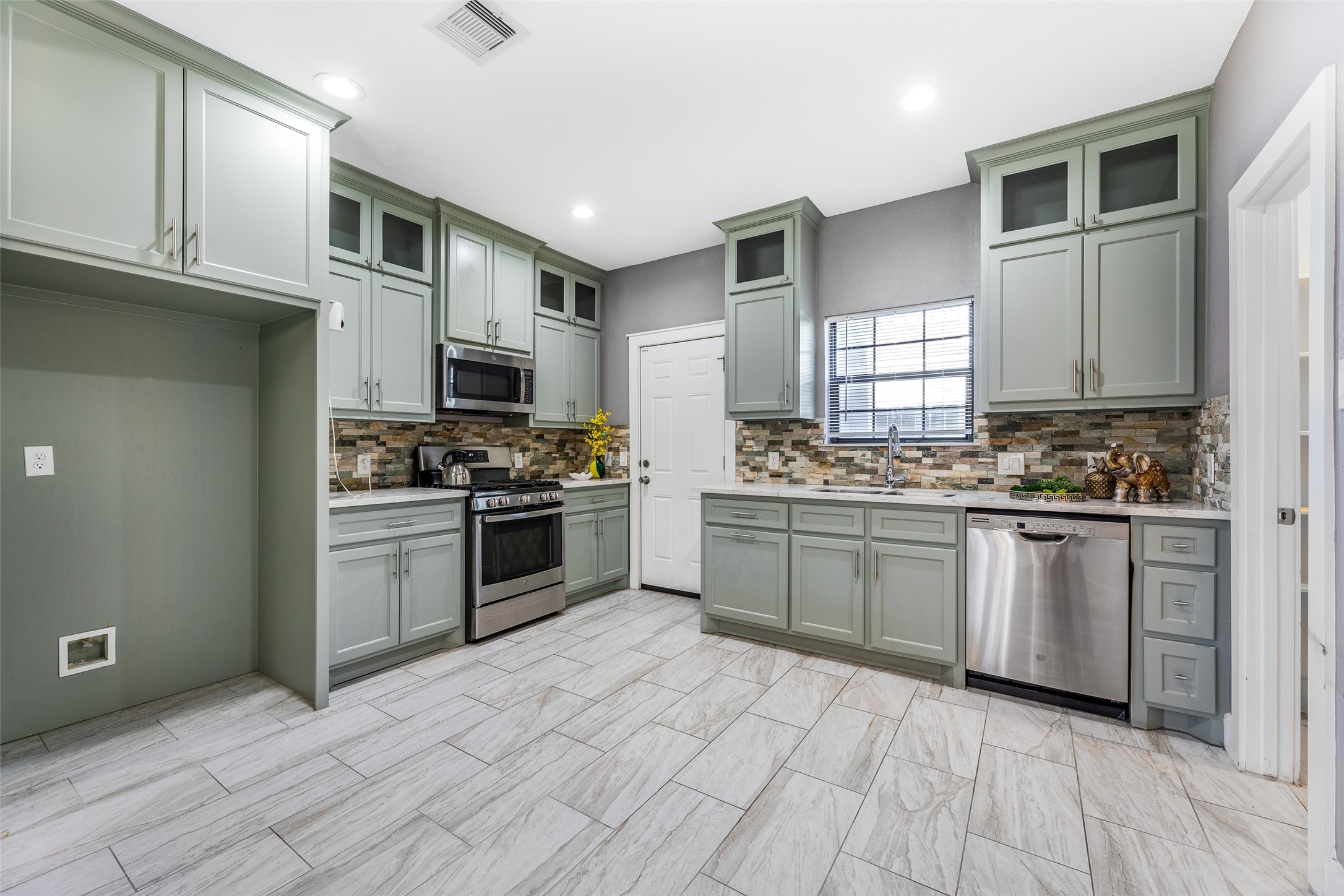 6501 Stratton Street Houston, TX 77023 - Photo 9 of 46 Beautiful kitchen featuring sage green cabinetry and stainless steel appliances.