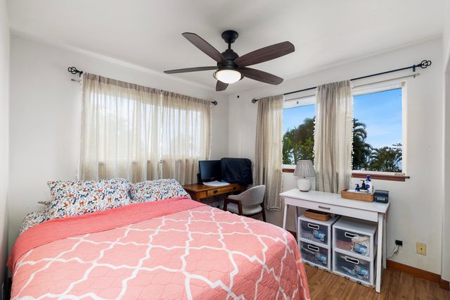 a bedroom with a bed and a large window with the outer view