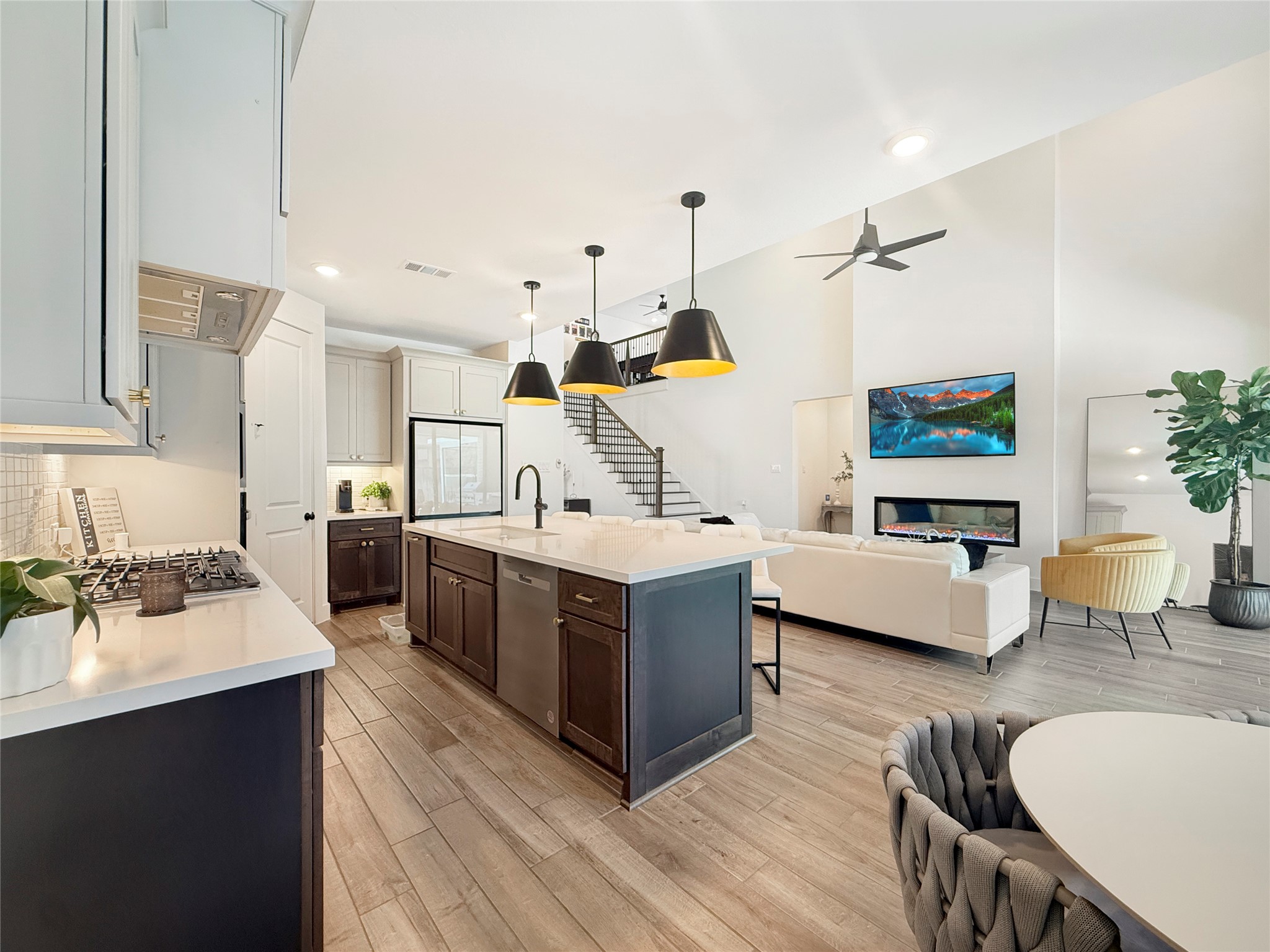 26918 Swanborough Road Spring, TX 77389 - Photo 13 of 50 Entertain with ease in this open kitchen boasting an oversized quartz island, sleek stainless appliances, and direct sightlines to the living room and covered outdoor patio — perfect for indoor-outdoor gatherings.
