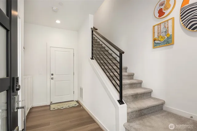 a view of entryway and hall with wooden floor
