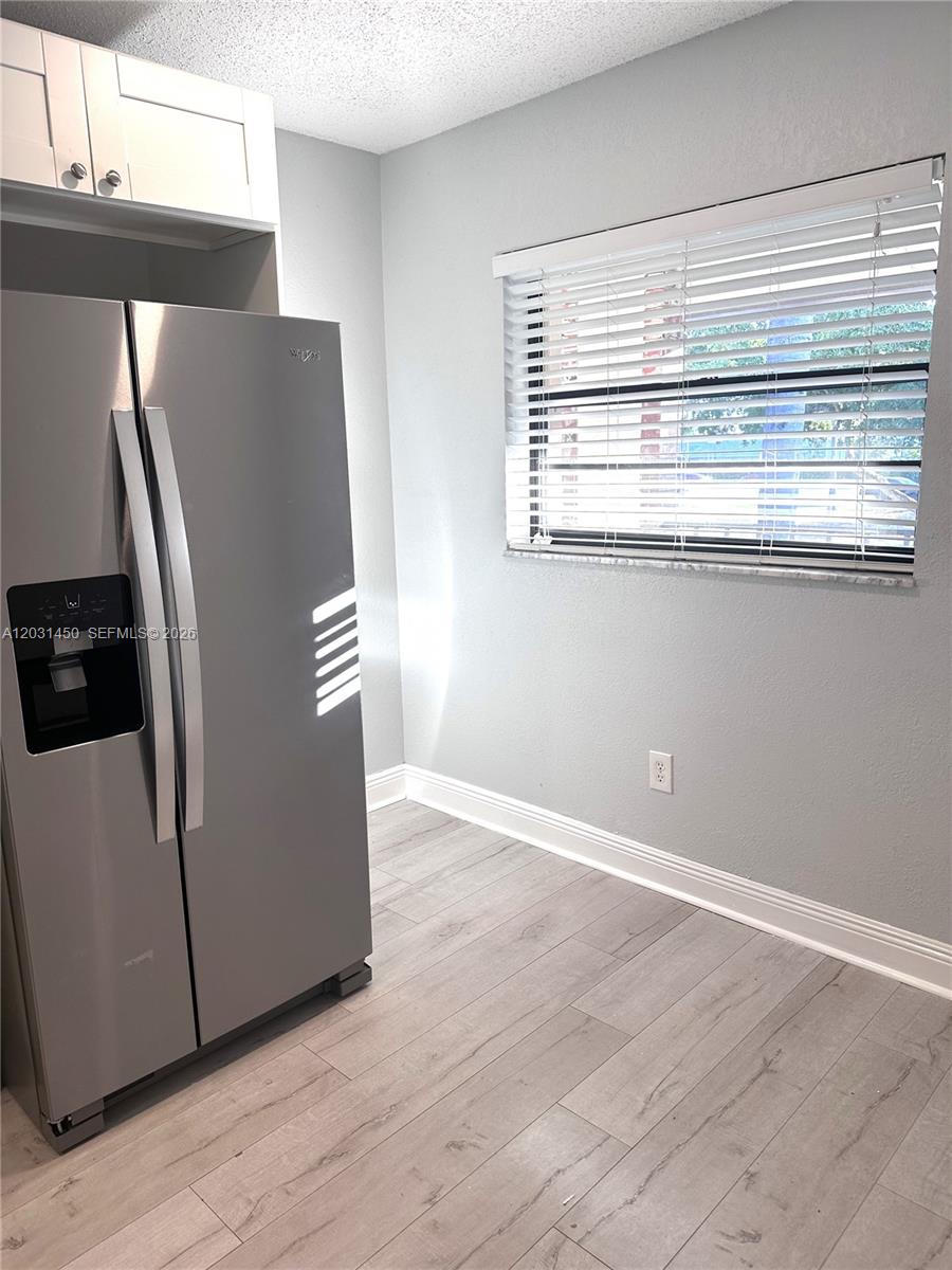 23398 Lyons Road, Unit 309 Boca Raton, FL 33428 - Photo 13 of 16 a view of a refrigerator in kitchen and an empty room