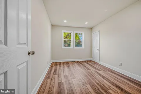 a view of a room with wooden floors and window