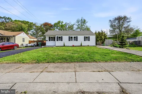 a front view of a house with a garden and trees