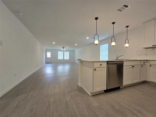 a view of a room with wooden floor and windows