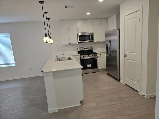 a kitchen with a sink stainless steel appliances and cabinets