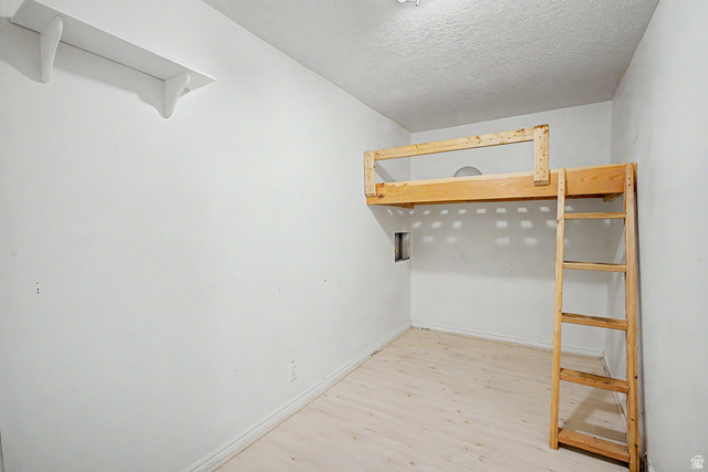 2058 California Avenue, Unit 2 Provo, UT 84606 - Photo 24 of 32 Room featuring a built-in wooden loft bed with ladder, light-toned wood-finish flooring, and white walls