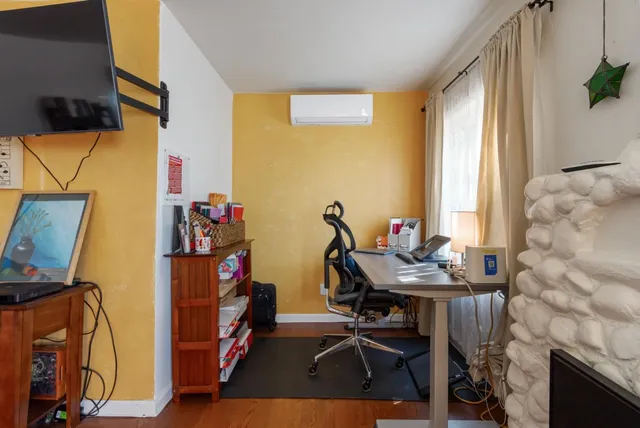 a view of a workspace with furniture and a window