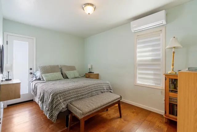 a bedroom with a bed and wooden floor