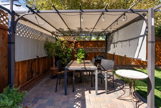 a view of a patio with table and chairs under an umbrella
