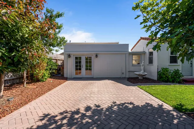 a view of backyard with potted plants and wooden fence