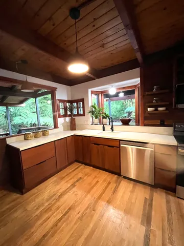 a large kitchen with stainless steel appliances wooden cabinets and a large window