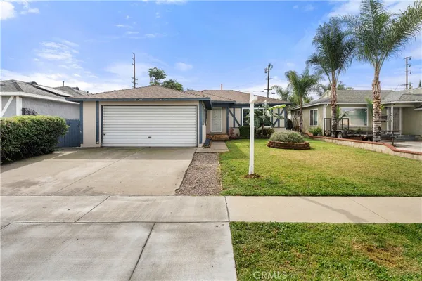 a front view of a house with a yard and potted plants