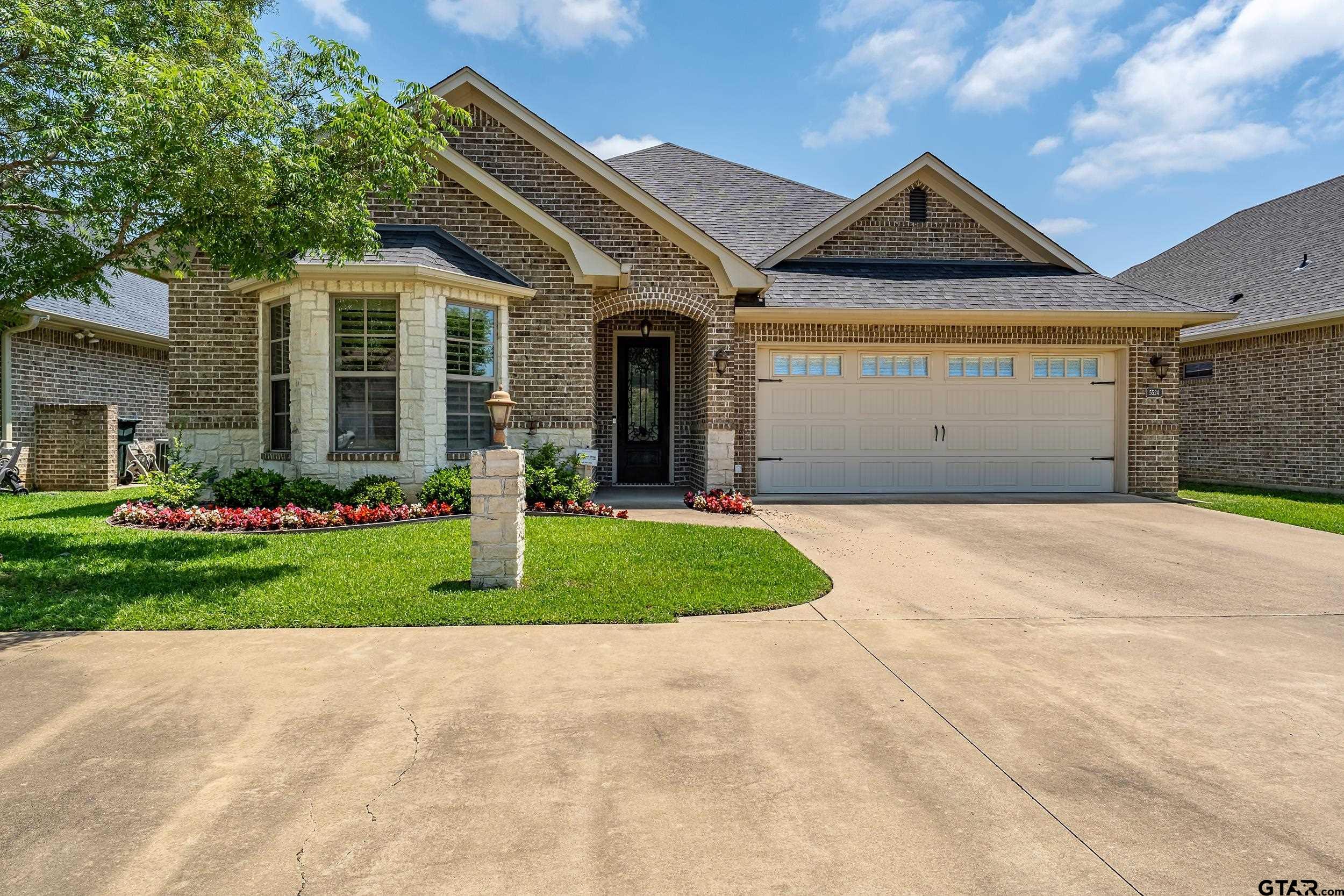 5524 Hollytree Drive Tyler, TX 75703 - Photo 1 of 27 a front view of a house with garden