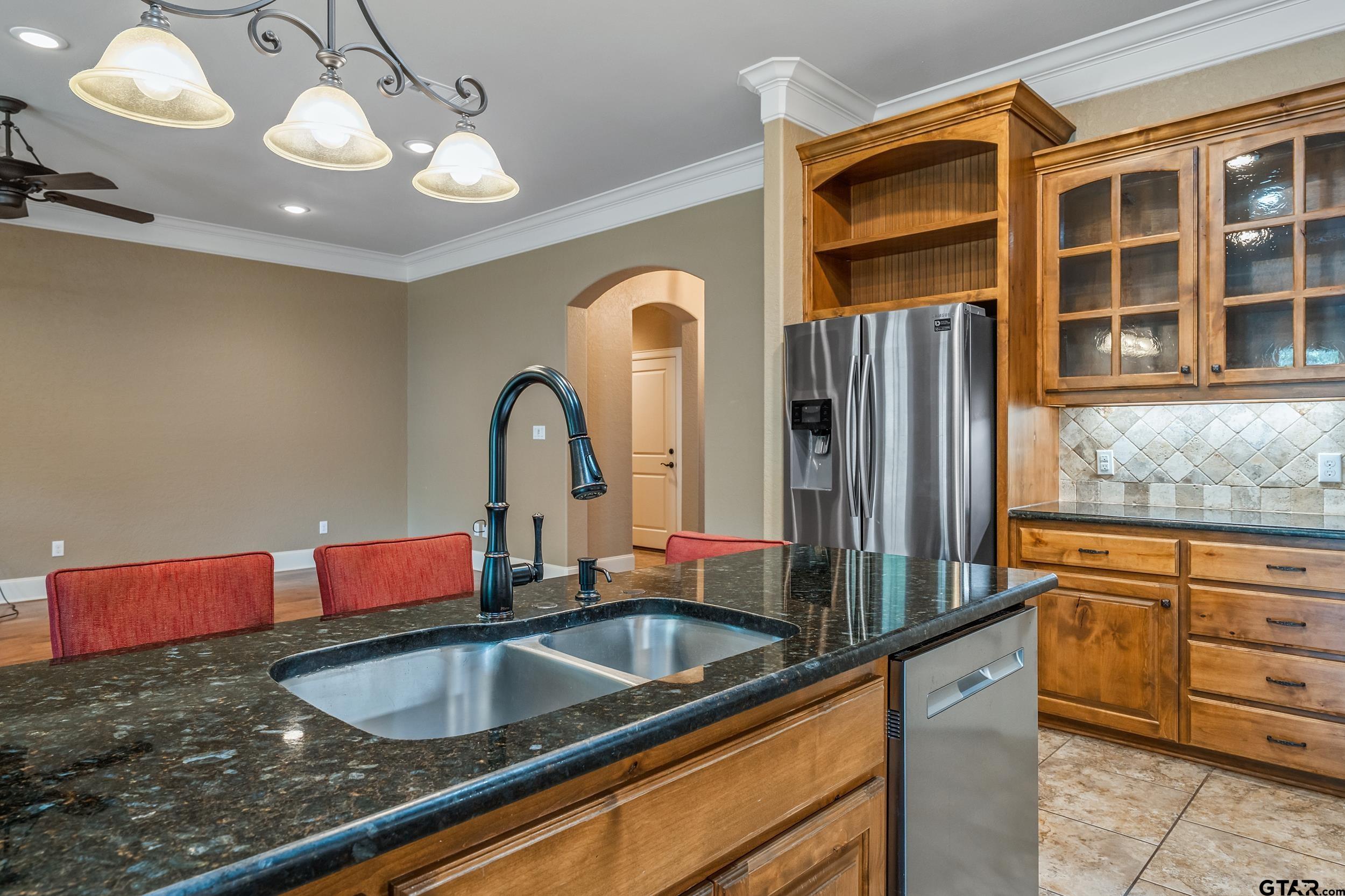 5524 Hollytree Drive Tyler, TX 75703 - Photo 13 of 27 a kitchen with stainless steel appliances granite countertop a sink a stove and a refrigerator